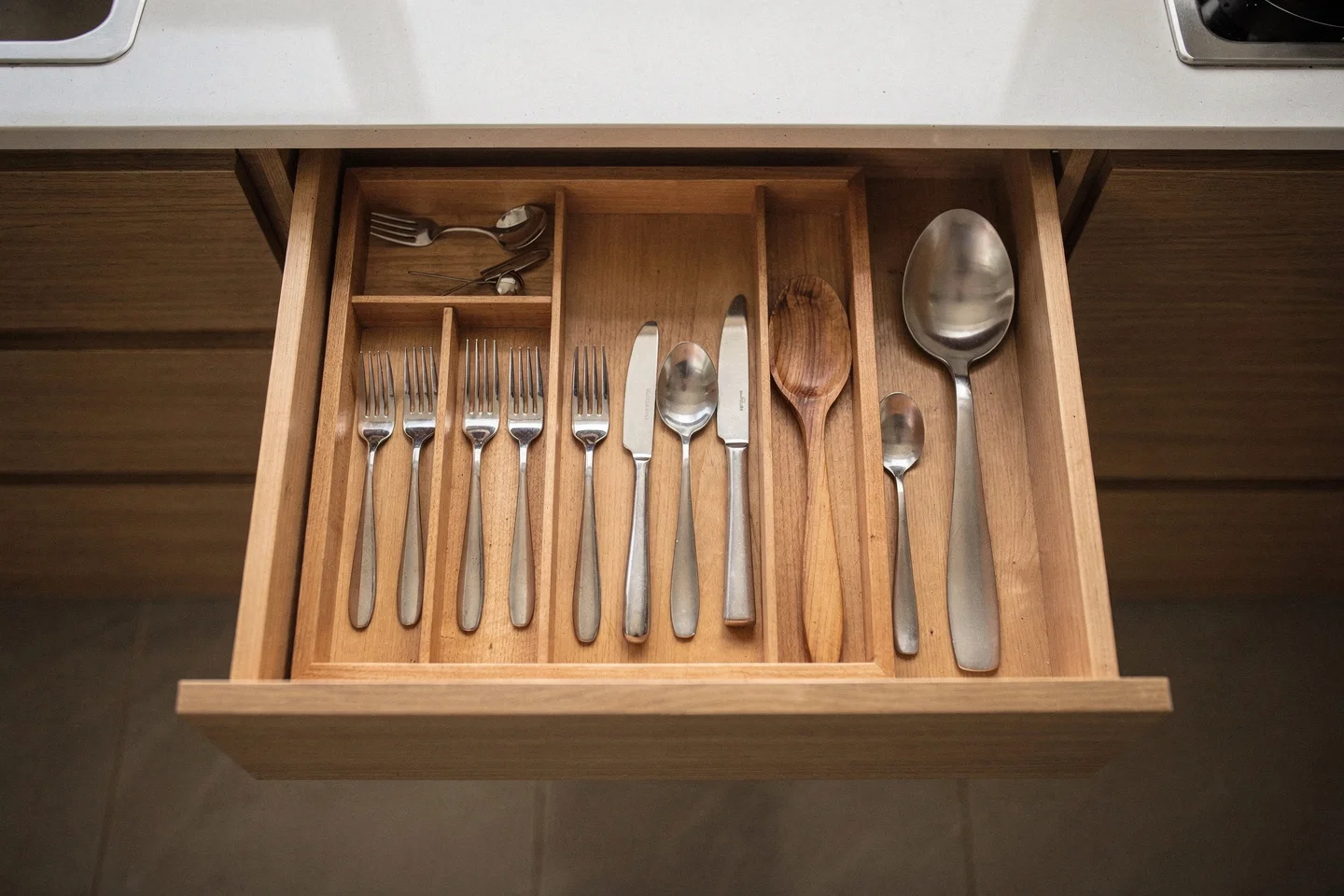 A custom timber drawer interior with fitted dividers in a Grainline kitchen